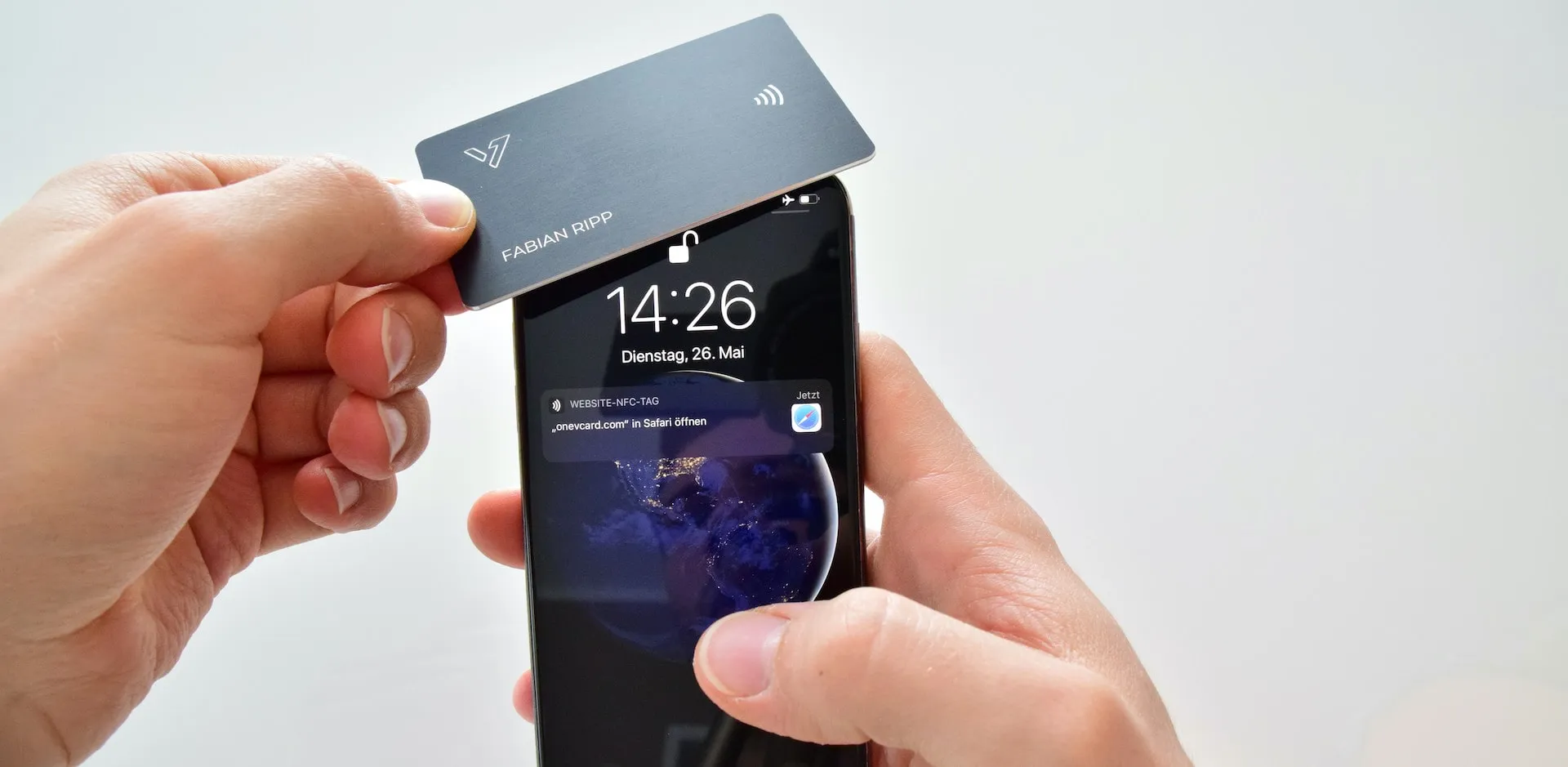 oneVcard Metal an ein Smartphone halten